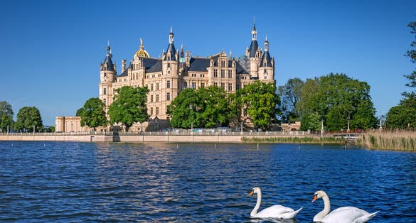View of the Schwerin medieval castle from the lake with swans, Germany.