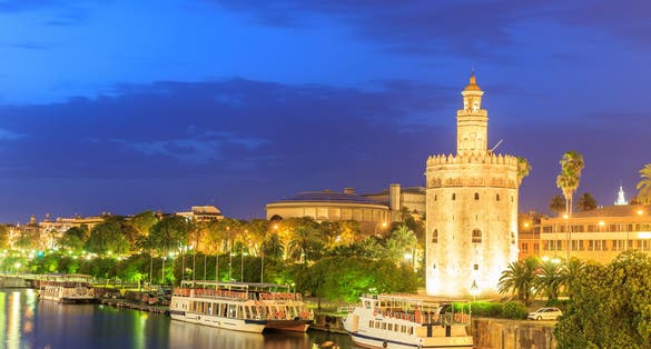 Photo of Golden Tower (Torre del Oro) of Seville, Andalusia, Spain over river Guadalquivir at sunset .