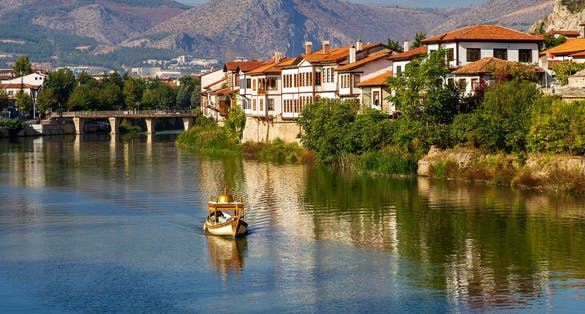 a boat on the river and historical ottoman houses by the river in Amasya