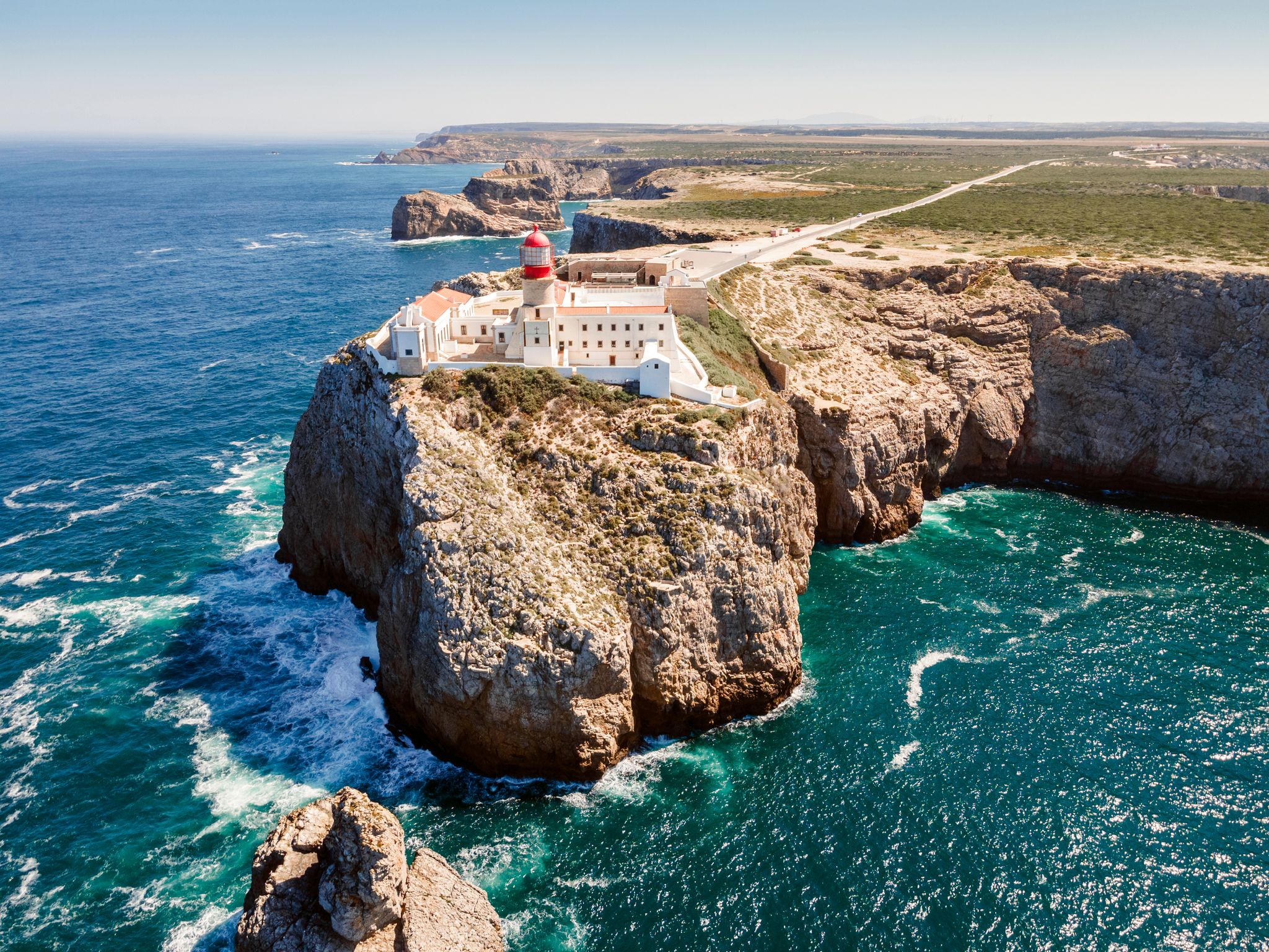 Photo of aerial view of beautiful lighthouse located on high cliffs of Saint Vincent cape in Sagres, Algarve, Portugal.
