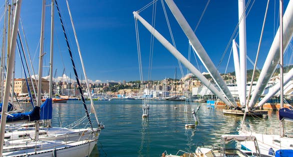 photo of Port Porto Antico harbor with luxury white yachts and attractions, Bigo construction in historical centre of old european city Genoa Genova with blue sky in clear summer day, Liguria, Italy