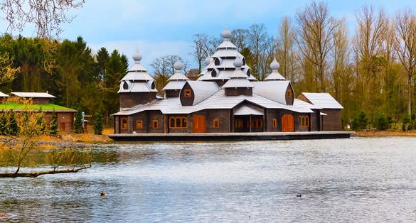 Photo of wooden ancient asian style temple, lake and trees in Pairi Daiza, Belgium.