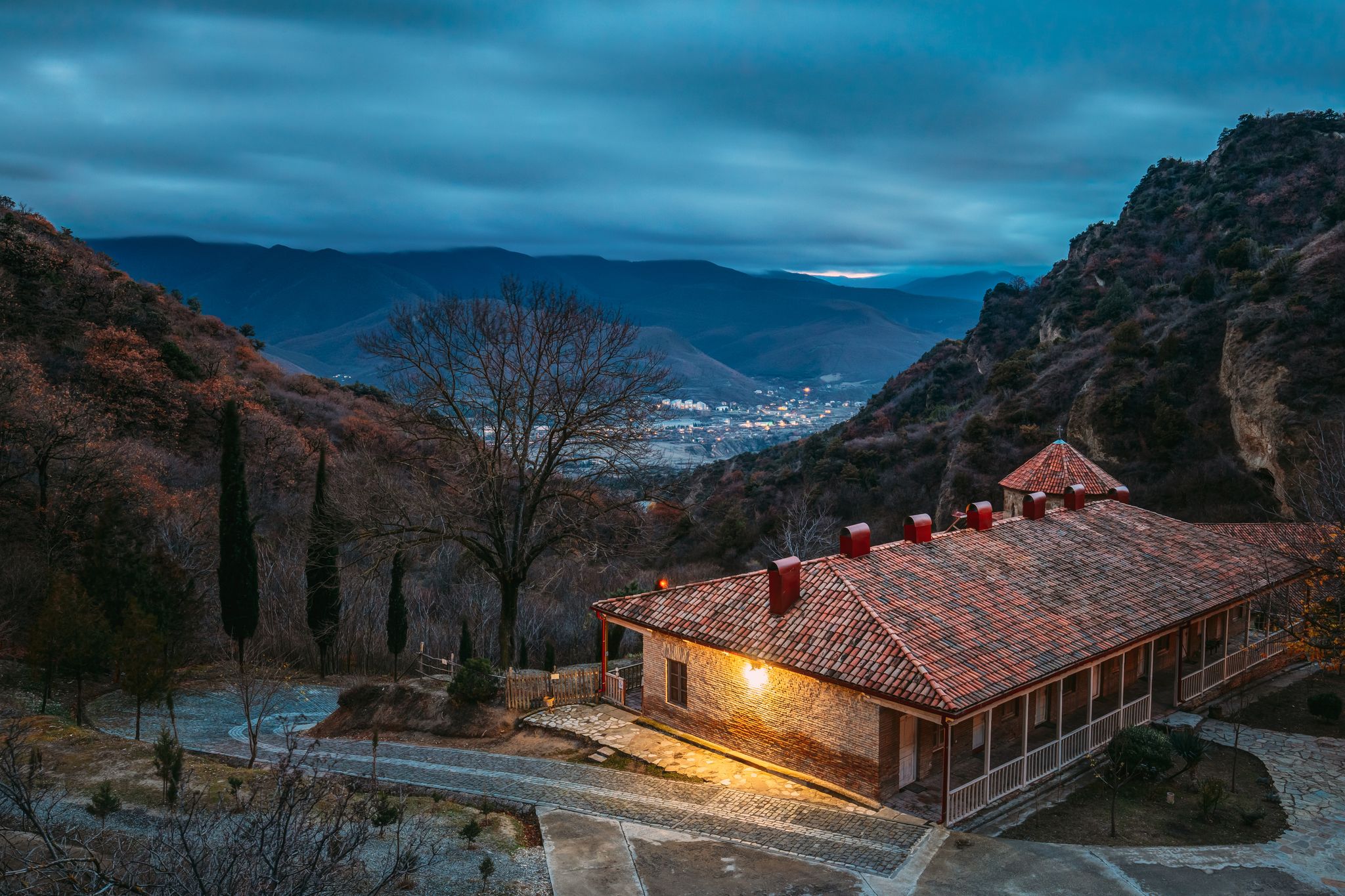 Photo of Shio-Mgvime Monastery. Upper Church Of Holy Virgin Or Theotokos, Central Part Of Medieval Monastic ShioMgvime Complex In Limestone Canyon In Autumn Sunset.