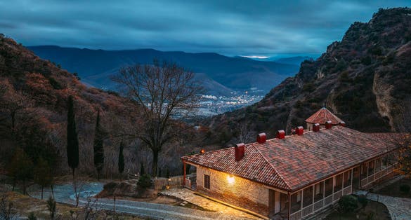 Photo of Shio-Mgvime Monastery. Upper Church Of Holy Virgin Or Theotokos, Central Part Of Medieval Monastic ShioMgvime Complex In Limestone Canyon In Autumn Sunset.