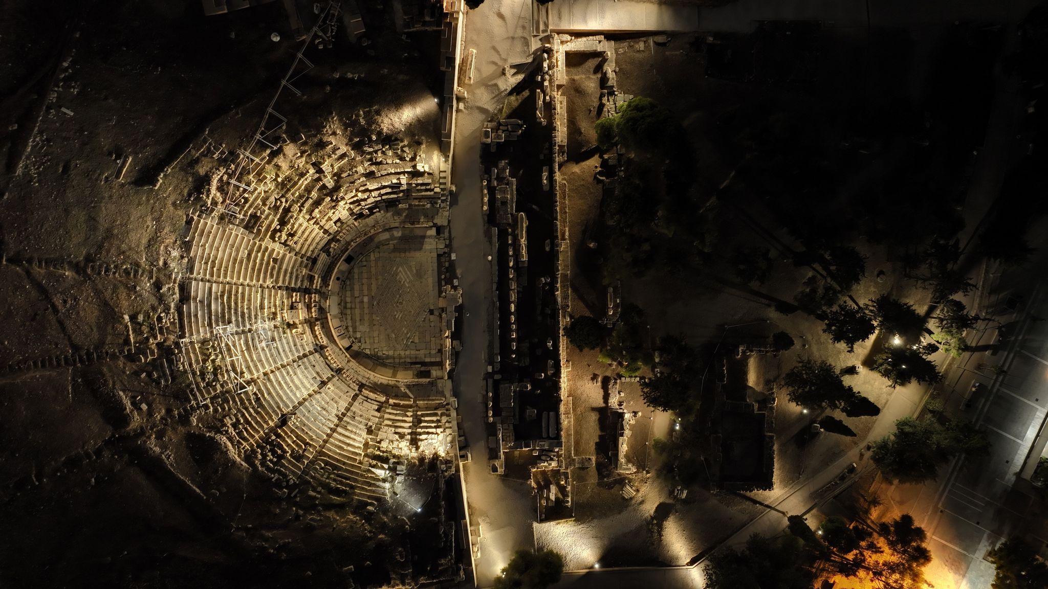 photo of Aerial drone night shot of iconic Theatre of Dionysus in the slopes of Acropolis hill, Athens historic centre, Attica, Greece,Athens Greece.