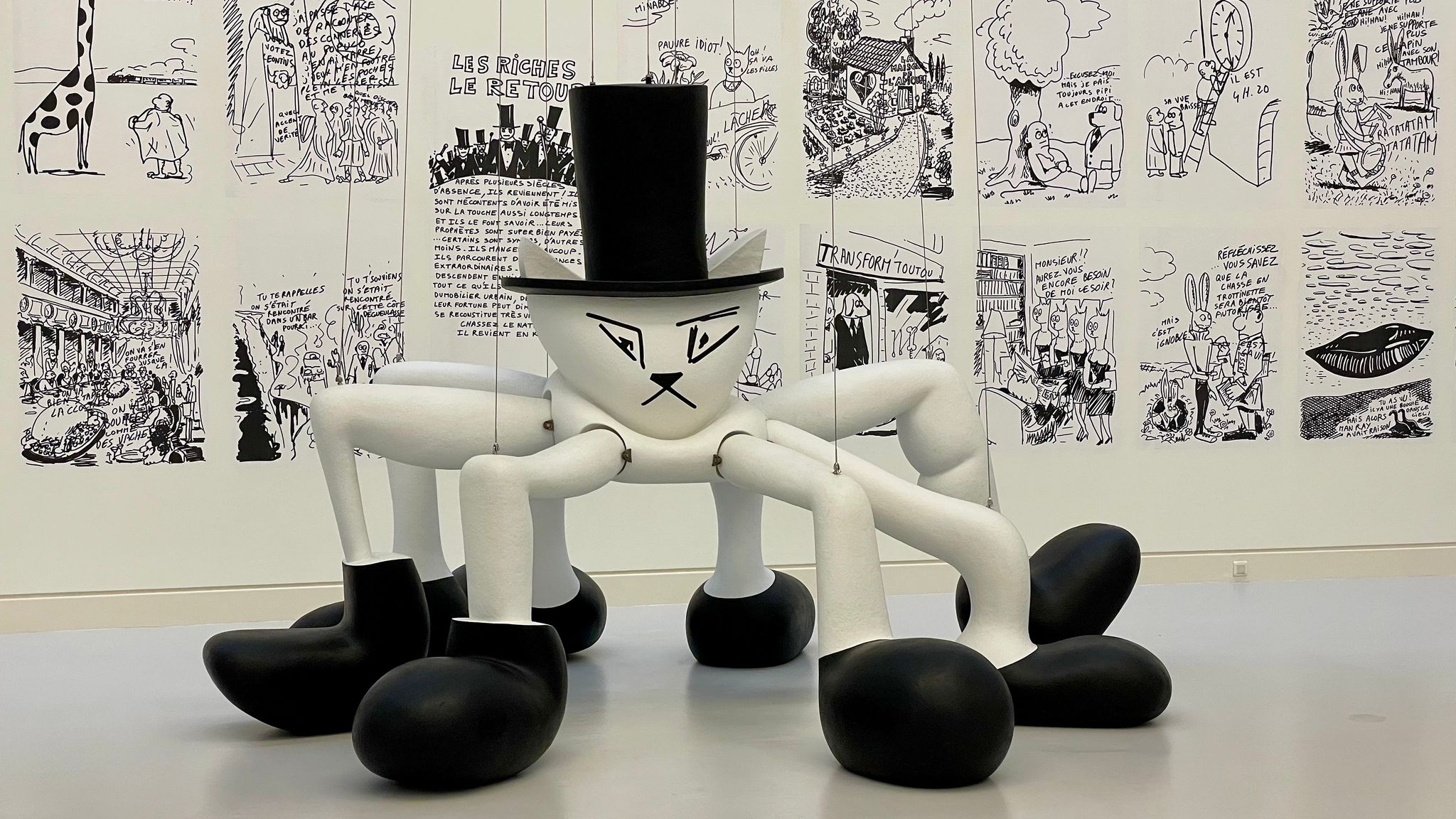 A cat in a hat with spider legs in boots on hanging cables at the Museum of Modern and Contemporary Art. Strasbourg, France.