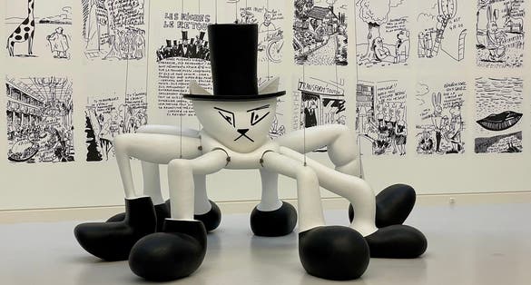 A cat in a hat with spider legs in boots on hanging cables at the Museum of Modern and Contemporary Art. Strasbourg, France.