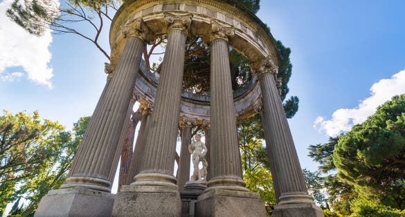 Photo of Small roman style temple with a goddess statue inside, sited at the "El Capricho" public park, in Madrid, Spain .