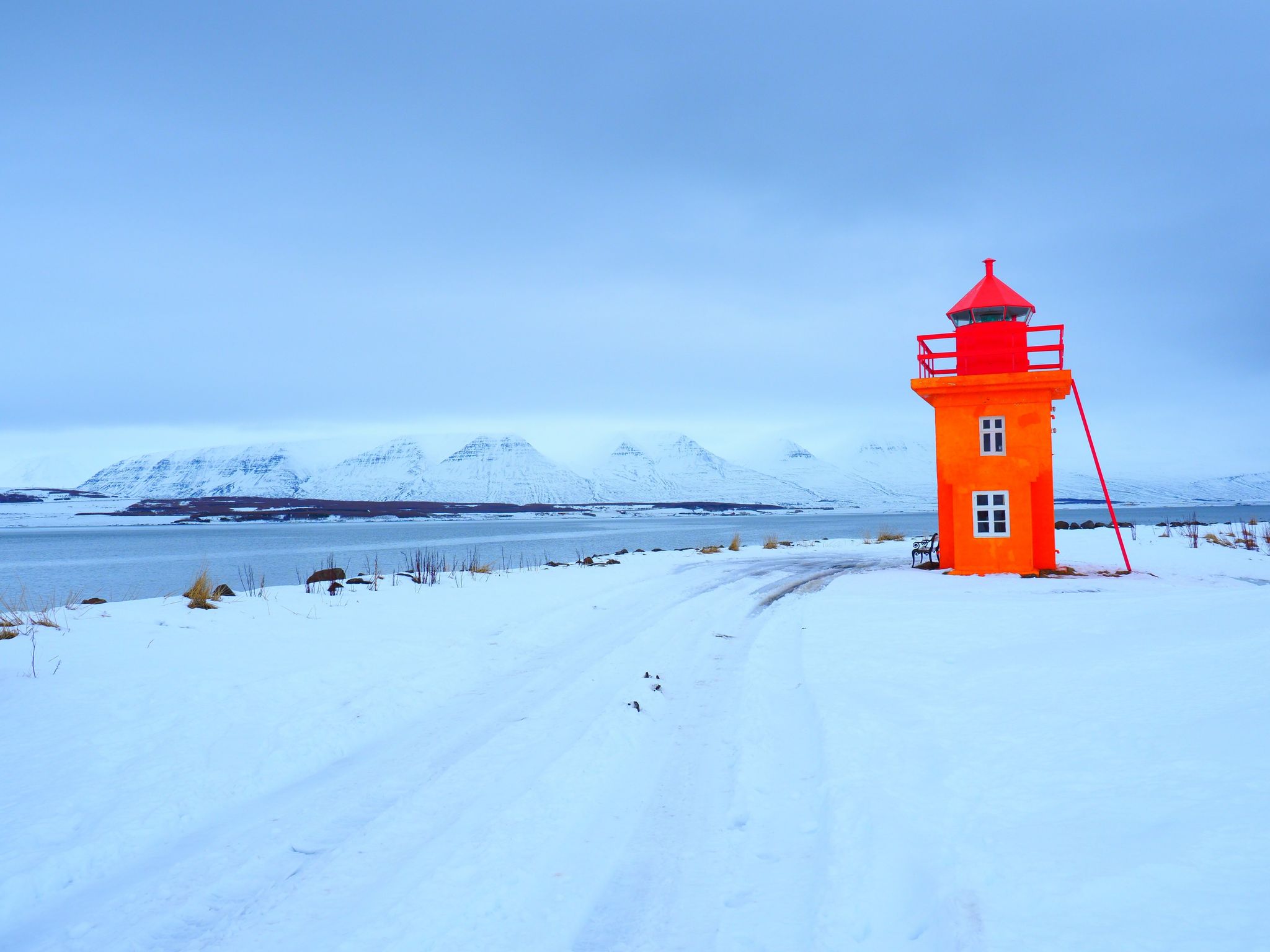 Beautiful yellow lighthouse, with the Atlantic surface as a background, Akureyri, Iceland .waves at the west coast of Iceland