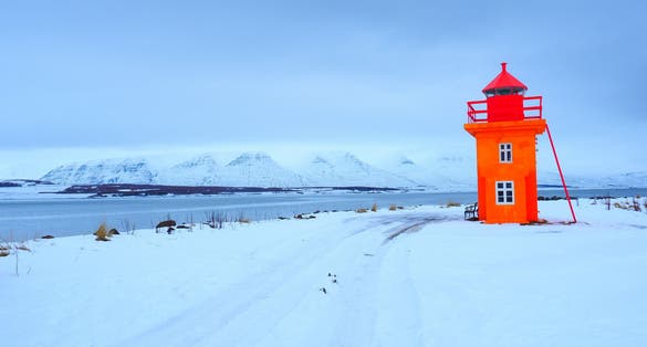 Beautiful yellow lighthouse, with the Atlantic surface as a background, Akureyri, Iceland .waves at the west coast of Iceland