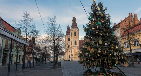 photo of view of Christmas tree in the main square of Gyongyos, Hungary with the Saint Bartholomew Church in the background.