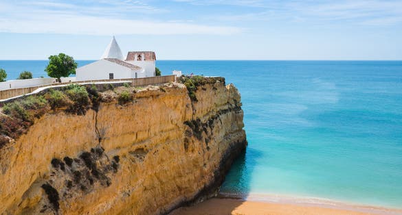 Photo of the Chapel of Nossa Senhora da Rocha on top of the spectacular cliffs on Nova Beach, Porches, Region Algarve, Portugal.