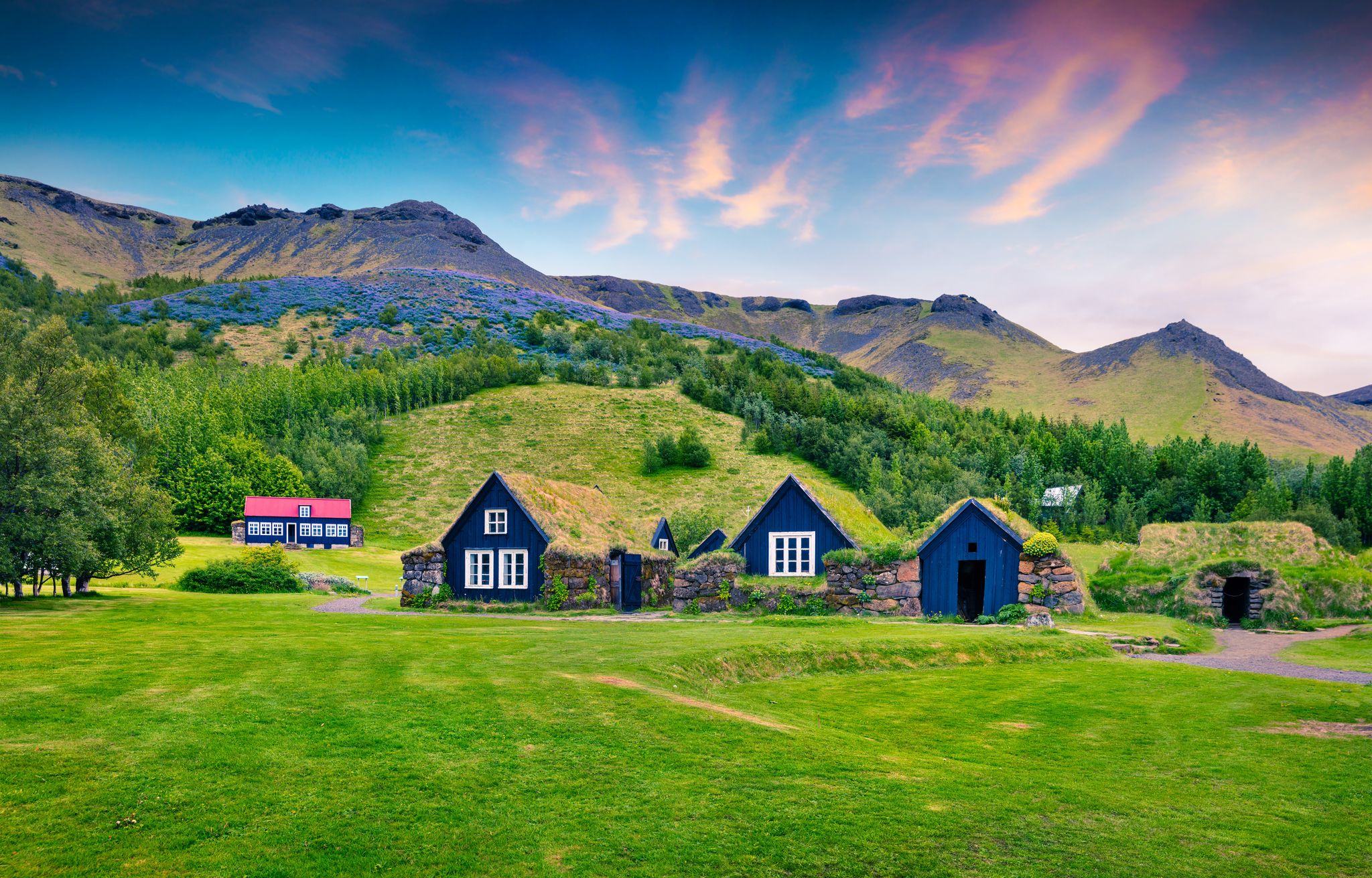 Photo of typical view of Icelandic turf-top houses with colorful summer sunrise in the Skogar village, south Iceland.