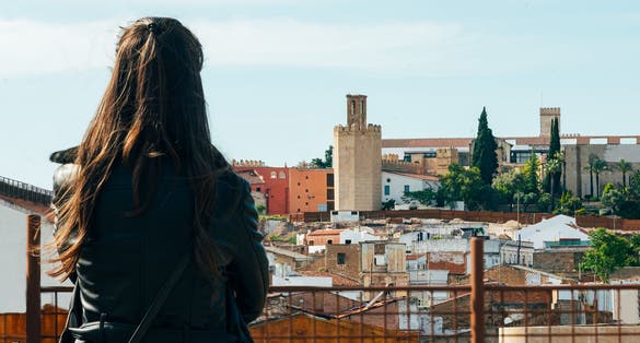 photo of backside woman looking city of Badajoz with Alcazaba of Badajoz in Spain.