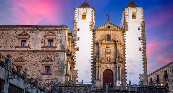 Photo of Plaza de San Jorge with the monumental Church of San Francisco in the historic center declared a UNESCO World Heritage Site in Cáceres, Spain at sunset .