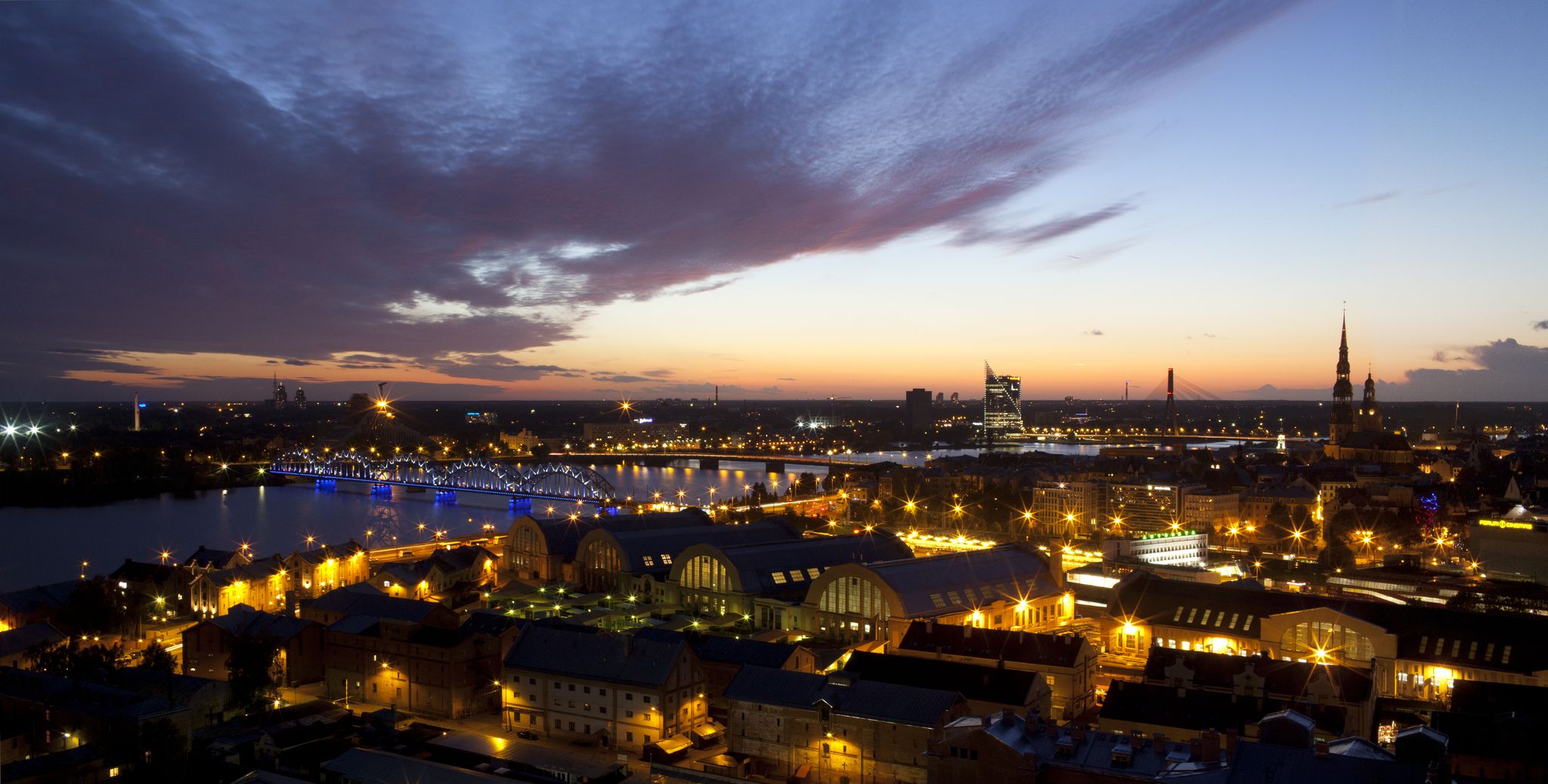 photo of city at night with church towers and bridges. Riga - the capital city of Latvia.
