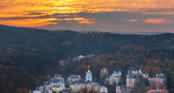 Photo of view to Karlovy Vary from Three Crosses Lookout at sunset, Czechia.