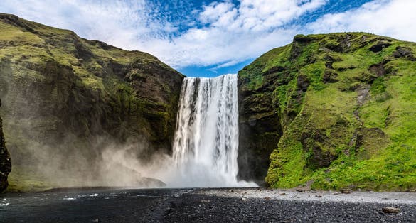 photo of skogafoss waterfall in southern Iceland during a summer day.