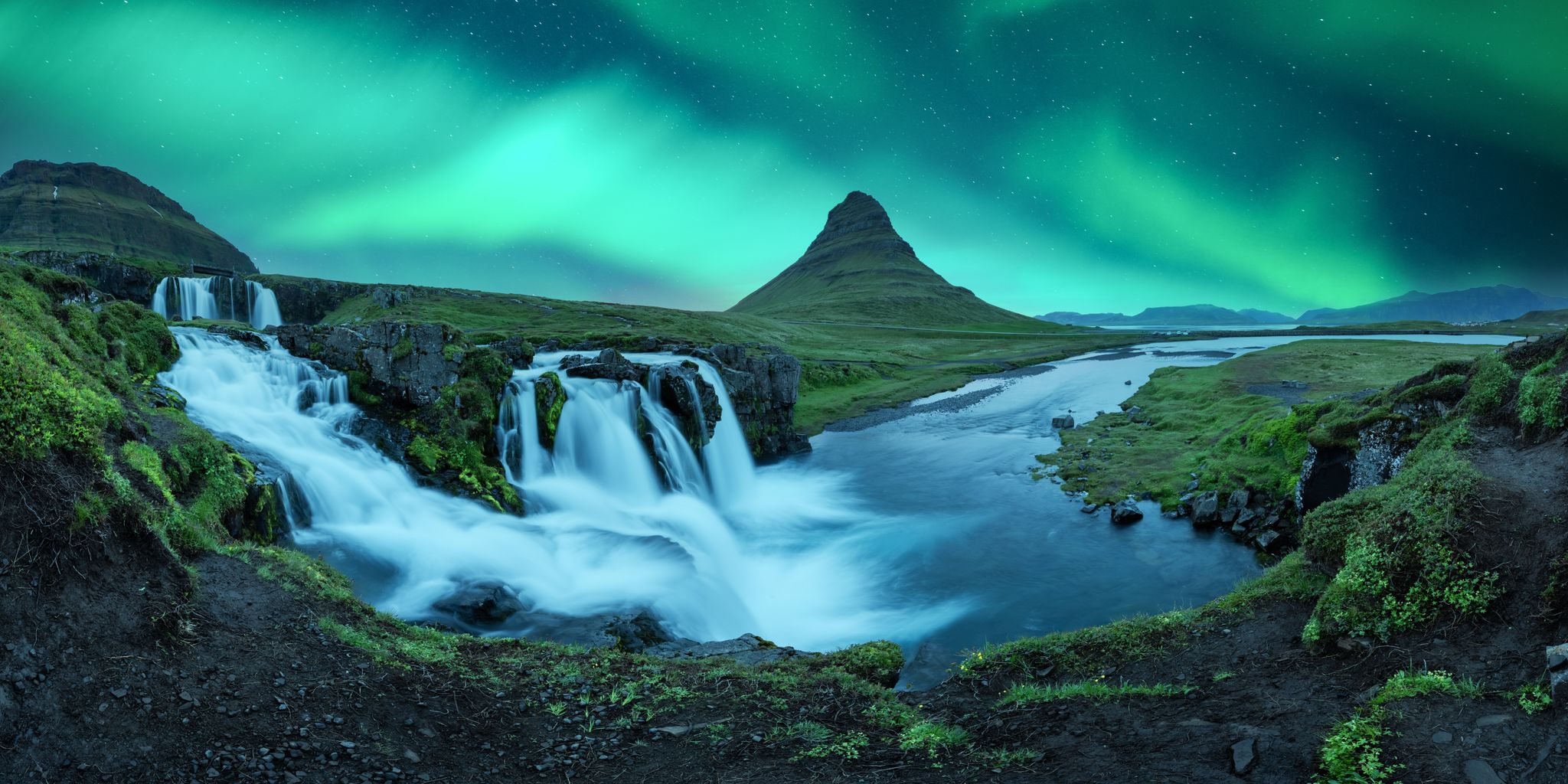 photo of aurora borealis northern lights over kirkjufellsfoss waterfall. Amazing night scene near kirkjufell volkano, Iceland. Landscape photography panorama.