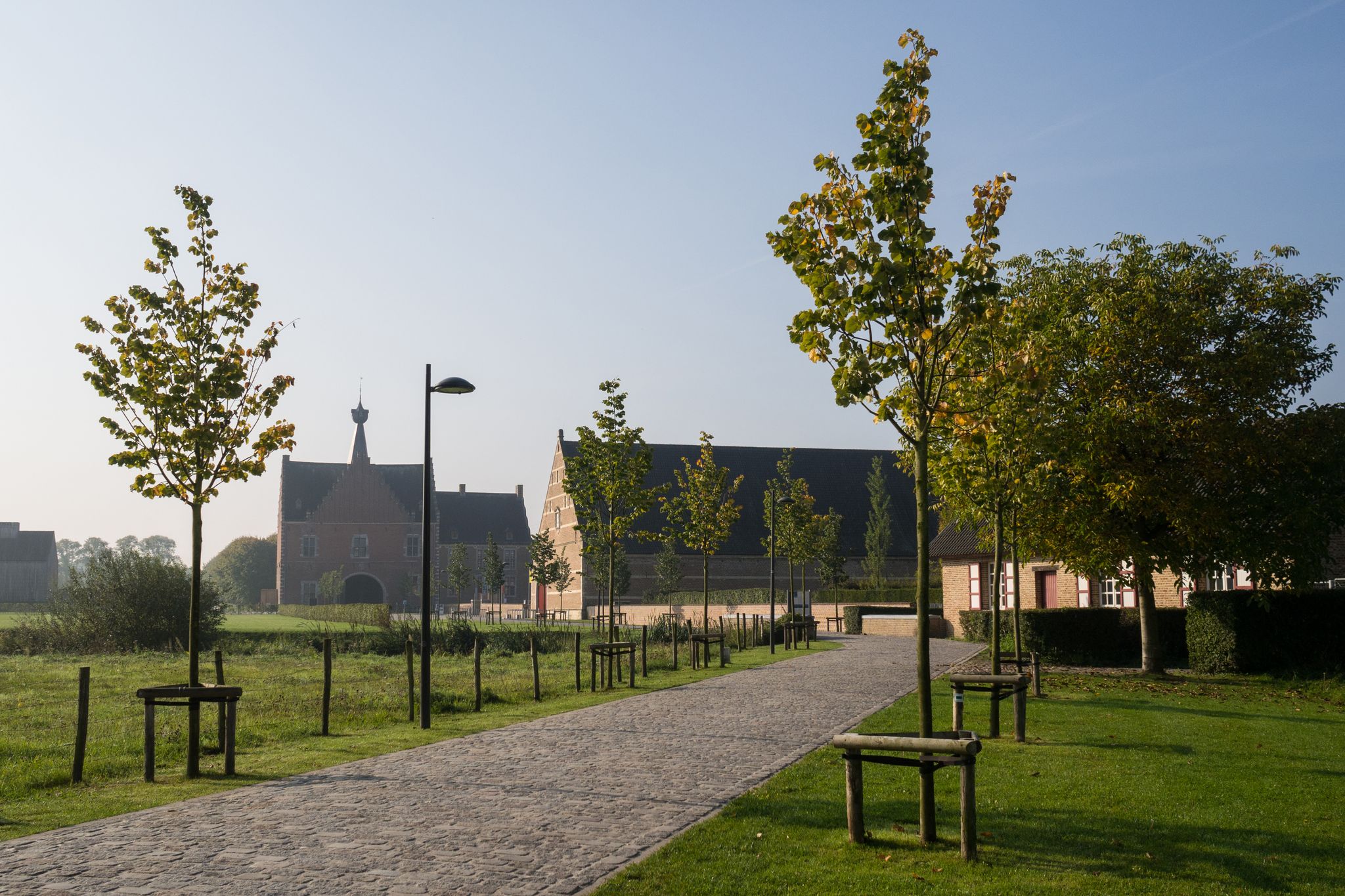 Photo of old abbey with young trees in the foreground, Hasselt, Belgium.
