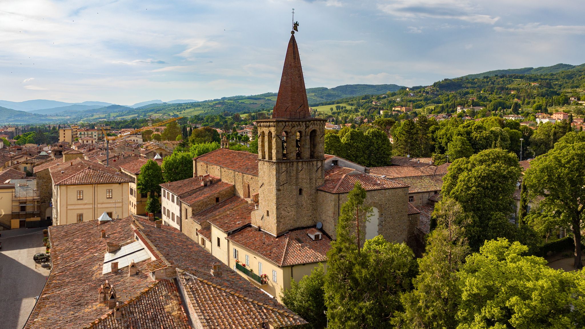 Panorama of the medieval town of Sansepolcro, Tuscany, Italy, with St.Francis (San Francesco) Church's bell tower, typical red roof tiles, cloudy sky and tuscanian hills in the distance.