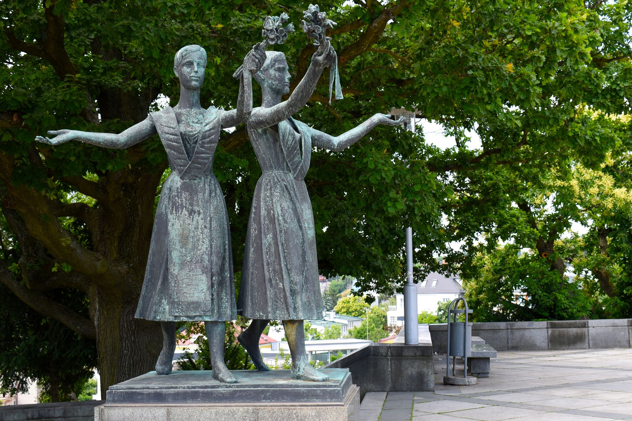 Two statues of young women with flowers in their hands at Slavin War Memorial Monument.