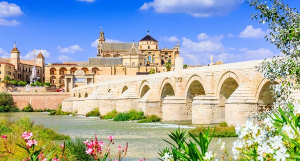 photo of view of Cordoba, Spain. The Roman Bridge and Mosque (Cathedral) on the Guadalquivir River.