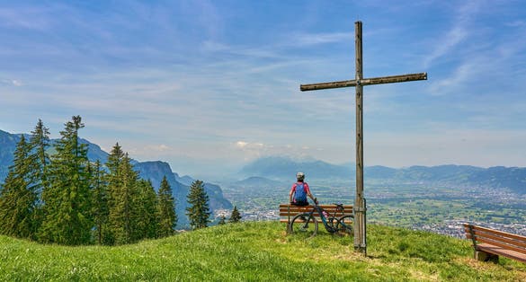 nice senior woman riding her electric mountain bike in the Bregenzer Wald mountain range above Bregenz and Lake of Constance in Vorarlberg, Austria