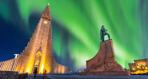 Photo of aurora borealis above hallgrimskirkja church in central of reykjavik city in Iceland.