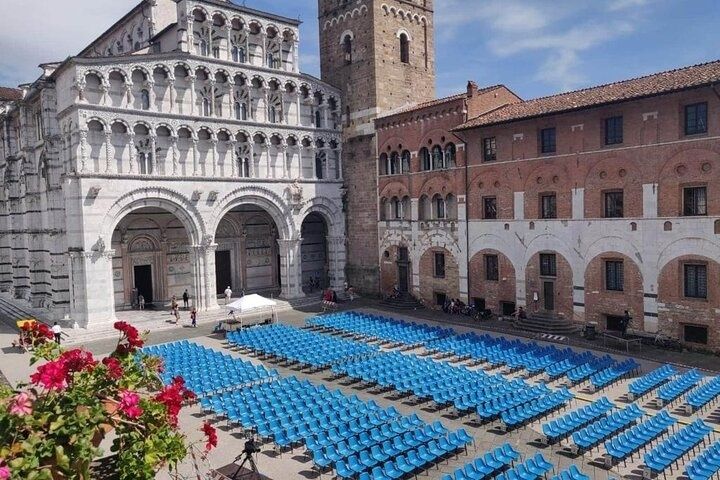 Blue chairs set up in front of San Michele in Foro church in Lucca, Italy for an outdoor event..jpg