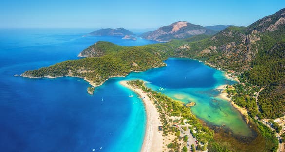 photo of amazing aerial view of Ölüdeniz-Kıdrak Nature Park, Turkey. Summer landscape with mountains, green forest, azure water, sandy beach and blue sky in bright sunny day.