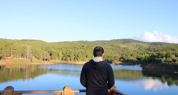 photo of man watching the lake in the Yozgat pine grove national park in Turkey.