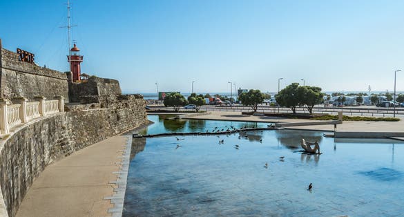 Photo of Perspective of the wall of the Santa Catarina fort with a small lake and birds in Figueira da Foz, Portugal.