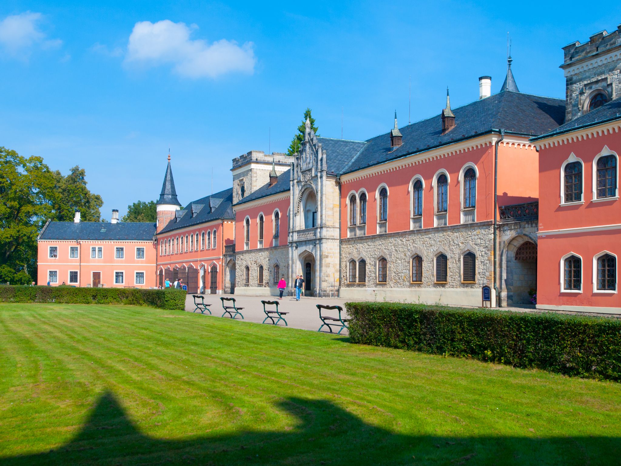 Photo of Sychrov Castle with typical pink facade. Neo-Gothic style chateau with beautiful english style park. Bohemian Paradise, Czech Republic.