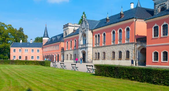 Photo of Sychrov Castle with typical pink facade. Neo-Gothic style chateau with beautiful english style park. Bohemian Paradise, Czech Republic.