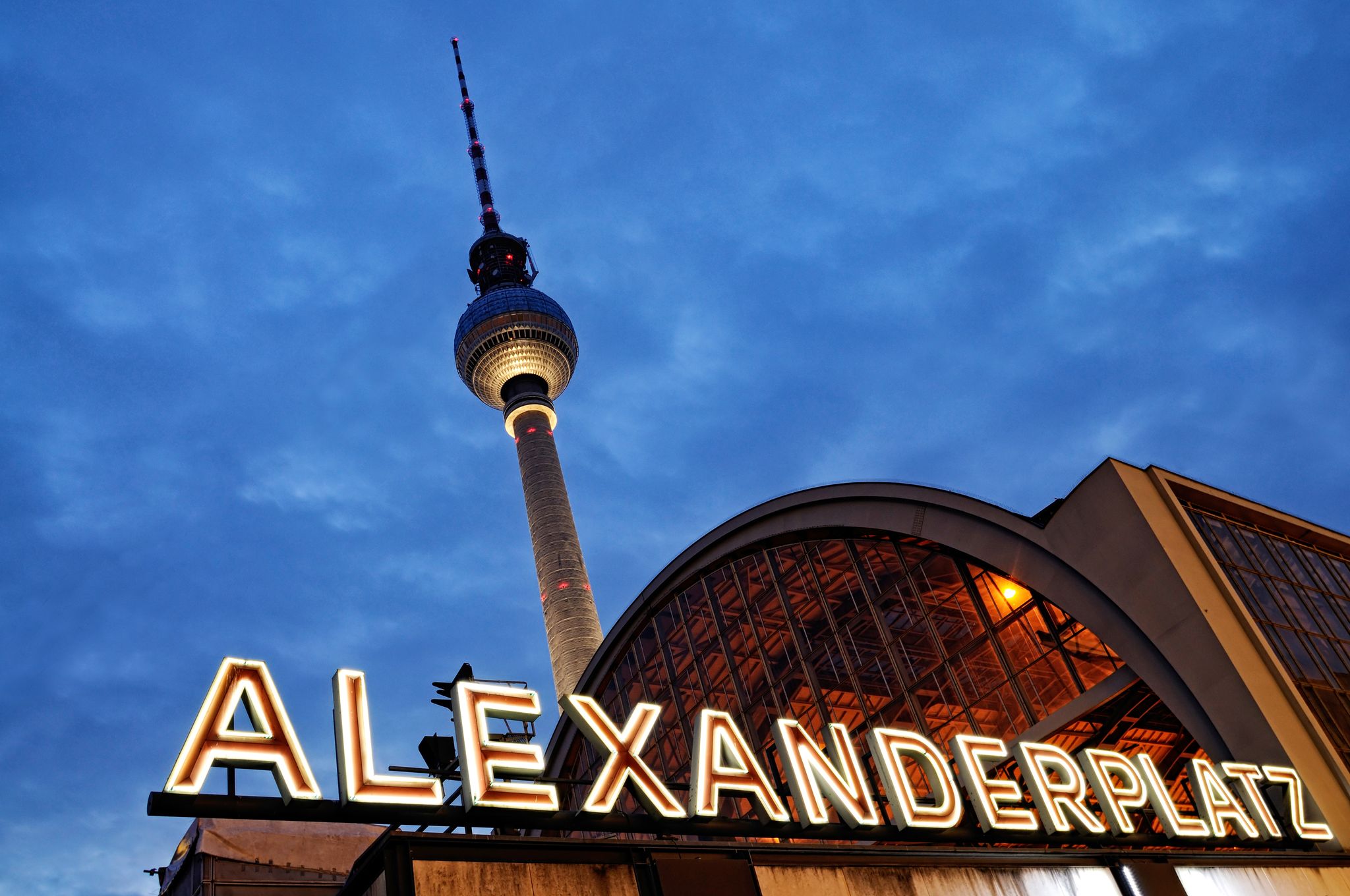 Photo of Night shot of the train station Berlin Alexanderplatz with the famous TV tower in the background.
