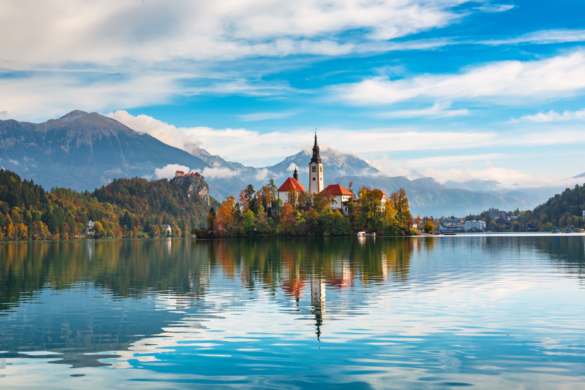 Photo of Church of Assumption in Lake Bled, Slovenia with blue sky and clouds in the autumn.