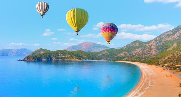 Photo of hot air balloon flying over spectacular oludeniz (ölüdeniz) lagoon and beach in Fethiye, Turkey.