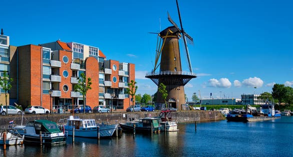 View of the harbour of Delfshaven with the old grain mill known as De Destilleerketel. Rotterdam, Netherlands
