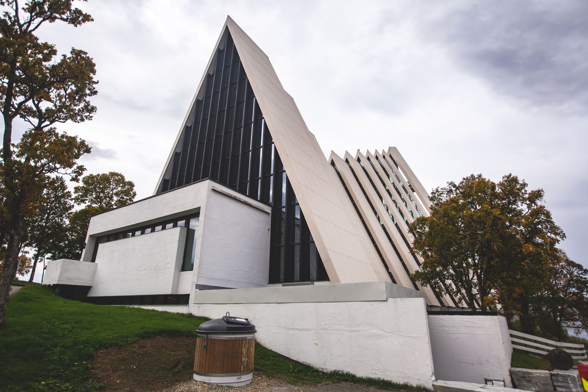 View of Tromso, with cathedral, Tromso Bridge, Tromsoya island, embankment and scenery beyond the city, Troms og Finnmark county, Norway, summer day.