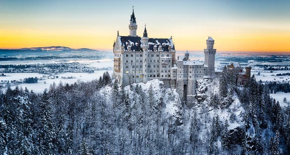 photo of Neuschwanstein Castle at sunset in winter landscape in Germany.