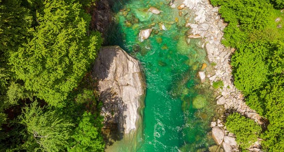 photo of Valle Verzasca - Aerial view of clear and turquoise water stream and rocks in Verzasca River in Ticino - Verzasca Valley in Tessin, Switzerland.