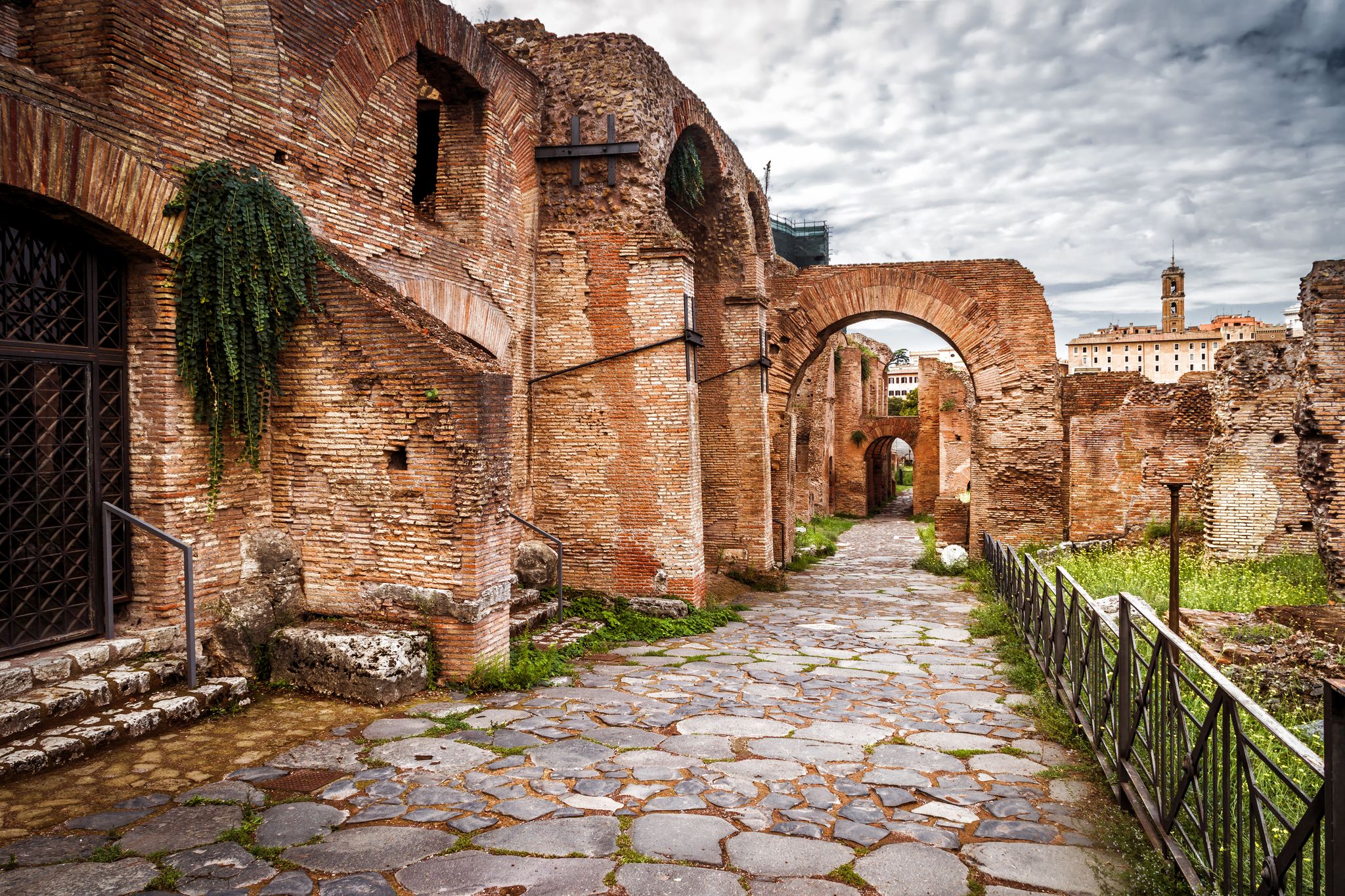 Old street on Roman Forum by Palatine Hill (Palatino), Rome, Italy. Scenery of Ancient buildings, tourist attractions of Rome. Cobbled road, walkway with ruins in Roma city. Theme of travel in Rome.