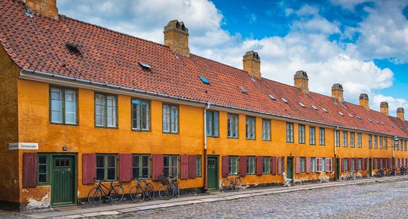Photo of nice old yellow houses of Nyboder, medieval district of Copenhagen, Denmark.