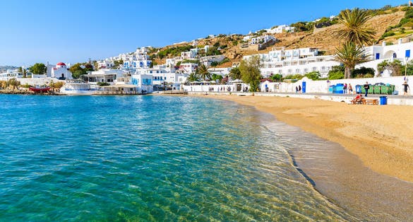 Photo of beautiful beach with turquoise sea water in Mykonos port, Mykonos island, Greece.