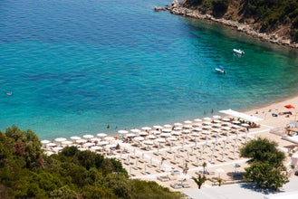 Photo of aerial view of  beach with turquoise sea water waves and umbrellas, Sarti, Greece.