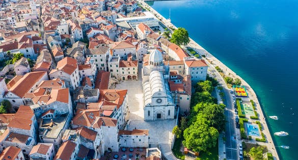 Photo of aerial view of the city of Sibenik with beach view in the summer morning, Croatia.