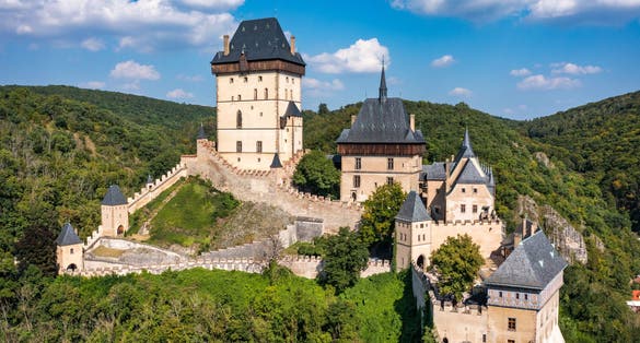 Photo of aerial view to The Karlstejn castle. Royal palace founded King Charles IV. Amazing gothic monument in Czech Republic.