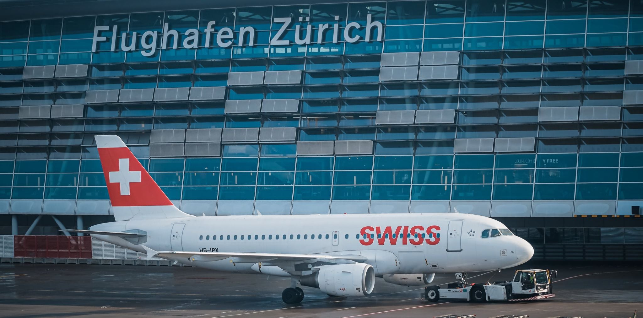 Swiss airplane parked at Zurich Airport terminal during winter travel season..jpg