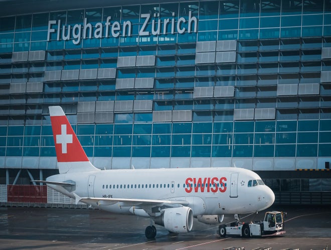 Swiss airplane parked at Zurich Airport terminal during winter travel season..jpg